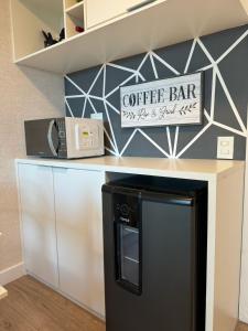 a kitchen counter with a coffee bar sign on it at Cômodo perfeito in Rio de Janeiro