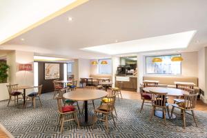 a restaurant with tables and chairs and a kitchen at Hampton by Hilton Sheffield in Sheffield
