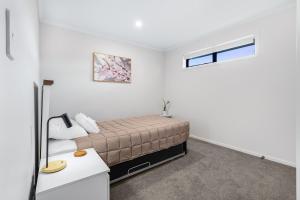 a bedroom with a bed and a window at The Tree House - Hamilton Holiday Home in Hamilton