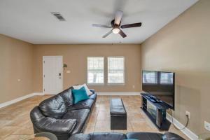sala de estar con sofá de cuero y TV de pantalla plana en 30A Getaway!, en Santa Rosa Beach