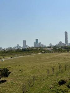 a field of grass with a city in the background at Apartamento cerca al malecón de Barranquilla in Barranquilla