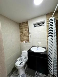 a bathroom with a toilet and a sink at Apartamento cerca al malecón de Barranquilla in Barranquilla