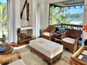 a living room with wicker chairs and a table at Luna Hotel Boutique - Beira Mar in Guarujá