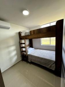 two bunk beds in a room with a window at Apartamento cerca al malecón de Barranquilla in Barranquilla