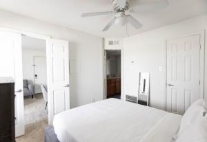 a white bedroom with a white bed and a ceiling fan at Wyndham 912 Urban Chic, Wd, Parking, Pool in Hampton