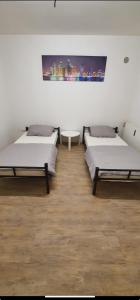 a room with three beds and a painting on the wall at Cityapartment12 bei Hauptbahnhof in Bremen