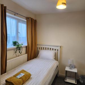 a small bedroom with a bed and a window at Exquisite Stays Free parking, fast WiFi, close to city centre in Kenton