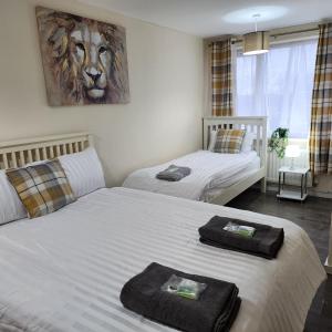 a bedroom with two beds and a lion painting on the wall at Exquisite Stays Free parking, fast WiFi, close to city centre in Kenton
