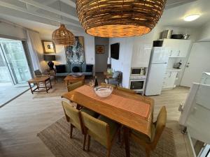 uma cozinha e sala de estar com uma mesa de madeira e cadeiras em 2 BR Cotton Tree Coastal Charm em Maroochydore