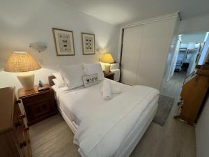 um quarto com uma grande cama branca e 2 candeeiros em 2 BR Cotton Tree Coastal Charm em Maroochydore