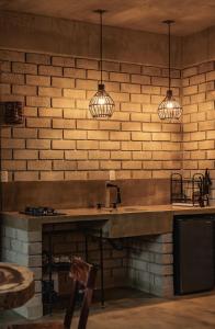 a kitchen with a sink and two pendant lights at Villa Macarena Apartamentos Boutique - Only Adults in Puerto Escondido