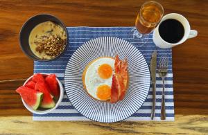 a table with a plate of eggs and fruit and a cup of coffee at Alma Tayrona Lodge in Los Naranjos +31 photos