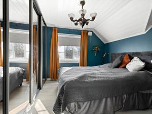 a bedroom with a bed with blue walls and a mirror at skogro in Fredrikstad