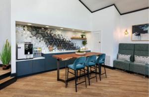 a kitchen with a table with blue chairs and wine bottles at Modern Luxe 2bd2ba I Free Parking I Wyndham in Hampton