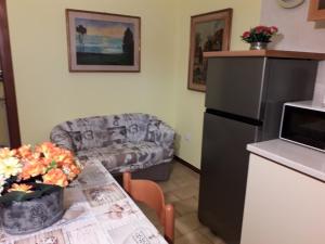 una cucina con frigorifero e tavolo con divano di LA CASA DI TERRY a Bergamo
