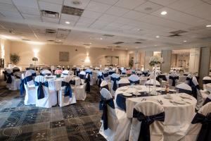 un salón de banquetes con mesas blancas con arcos azules en Holiday Inn Weirton-Steubenville Area, en Weirton