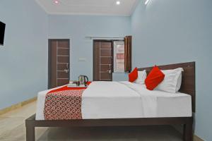 1 dormitorio con 1 cama grande con almohadas rojas en Flagship Hotel Ansh Plaza en Jaipur