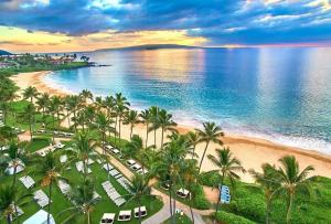 an aerial view of a beach with palm trees and the ocean at Maui Beachside Retreat in Wailea