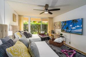 a living room with a couch and a tv at Maui Beachside Retreat in Wailea