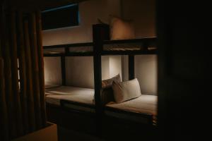 two bunk beds in a dark room with a pillow at Everyday Sunday Formerly Carl's Island Inn in Bantayan Island