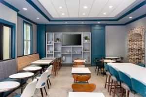 a restaurant with tables and chairs and a flat screen tv at Hampton Inn Savannah Historic District in Savannah