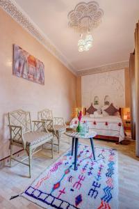 a bedroom with a bed and a table and chairs at Riad Amalia in Marrakech
