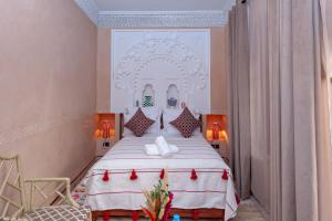 a bedroom with a large white bed with red accents at Riad Amalia in Marrakech
