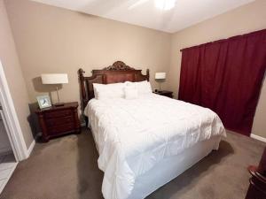 a bedroom with a large white bed and red curtains at Destin Harbor Getaway in Destin