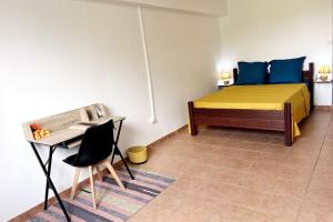 una camera da letto con un letto, una scrivania e un tavolo di appartement entier en Martinique Le Khan a Le Robert