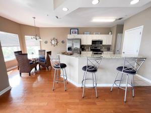 a kitchen with a bar with chairs and a counter top at Destin Harbor Getaway in Destin +5 photos