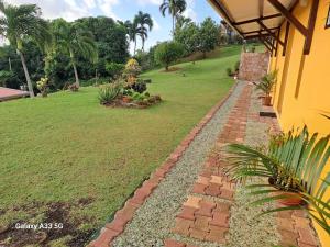un giardino con passerella in mattoni accanto a una casa di appartement entier en Martinique Le Khan a Le Robert