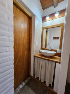 a bathroom with a sink and a mirror at Punto Sur Cabañas in El Bolsón