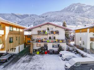 a apartment building with cars parked in a parking lot at Winter Chalet Kaprun in Kaprun