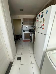 uma cozinha com um frigorífico branco com ímanes em Apartamento Completo Próx Hangar em Belém