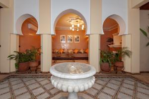 a large lobby with a fountain in the middle of a room at Riad Amalia in Marrakech