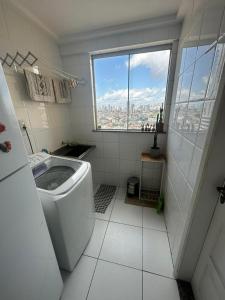 Baño blanco con ventana y aseo en Apartamento Completo Próx Hangar en Belém