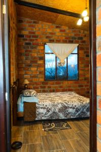 um quarto de tijolo com uma cama e uma janela em Casa Ensueño em Catamayo