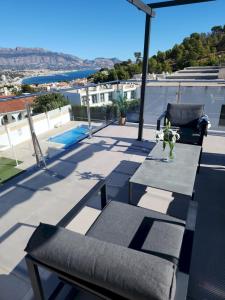 a patio with a table and chairs on a roof at Magnificent view and pool in Albir