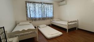 um pequeno quarto com 2 camas e uma janela em Casa Las Brisas, Puerto Azul em Ternate
