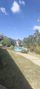a large yard with a swimming pool and trees at Casa Las Brisas, Puerto Azul in Ternate