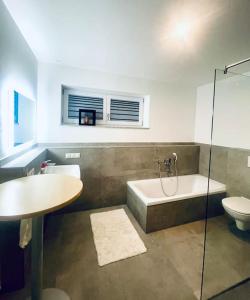 een badkamer met een bad, een wastafel en een toilet bij Highlight! Stilvolle 100m2 mit Büro Nähe München in Mühldorf