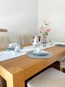 a wooden table with two tea cups and plates on it at Highlight! Stilvolle 100m2 mit Büro Nähe München in Mühldorf