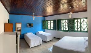 Habitación con 2 camas y pared azul en Pousada da Rita, en Lençóis