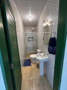 a bathroom with a white sink and a toilet at Pousada da Rita in Lençóis