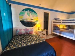 Las Catalinas Coronado في بلايا كورونادو: غرفة نوم مع سريرين بطابقين مع قارب شراعي على الحائط
