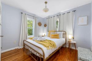 una camera da letto con un letto con una coperta gialla sopra di Tiny Home - 3 MI to Downtown & Winter Park a Orlando