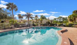 a swimming pool in a resort with palm trees at Cozy 2-Bedroom Condo in Prime Siesta Key Location in Sarasota