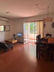 ein Wohnzimmer mit einem Esstisch und einem TV in der Unterkunft Lujoso Dpto en Zona Norte in Salta