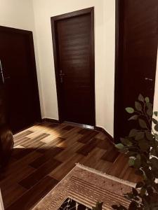 a room with two doors and a wooden floor at Be my guest Apt/kafr abdo in Alexandria