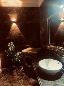 a black bathroom with a sink and a mirror at Be my guest Apt/kafr abdo in Alexandria